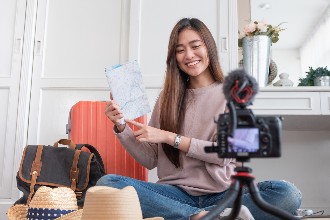 Asian young female blogger recording vlog video with vacation preparing to travel trip at home.online influcencer on social media concept